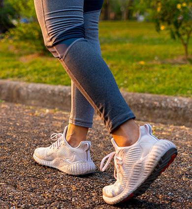 fit person running along gravel trail on a sunny day