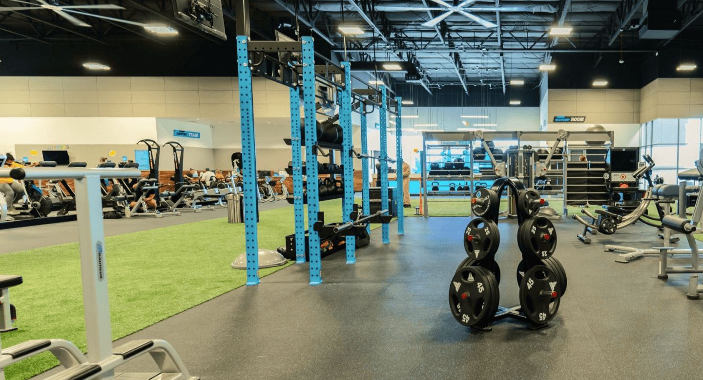 a rack of barbell weights in an empty gym floor with eos branding