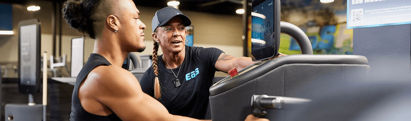 personal trainer hyping of eos gym member on smart equipment about to perform a row