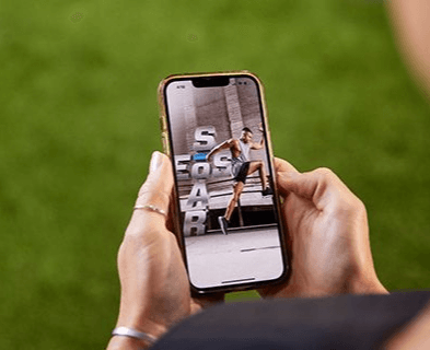 A person holding a smartphone displaying an EōS Mobile app