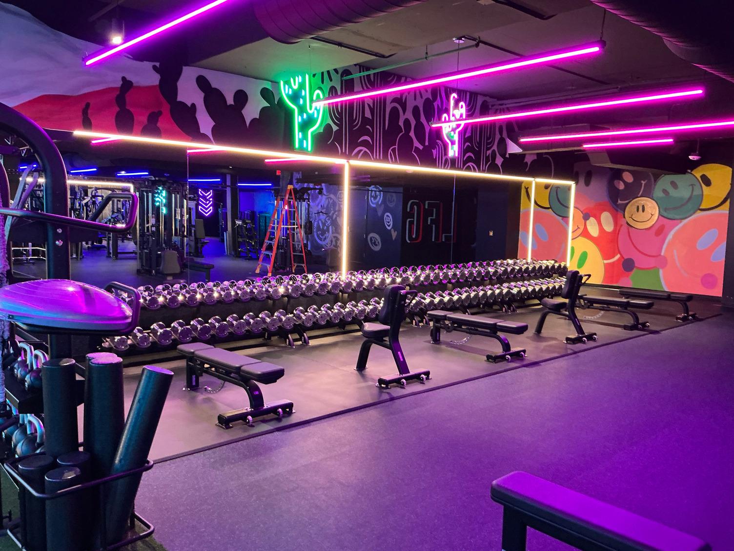 neon workout area with free weights and benches