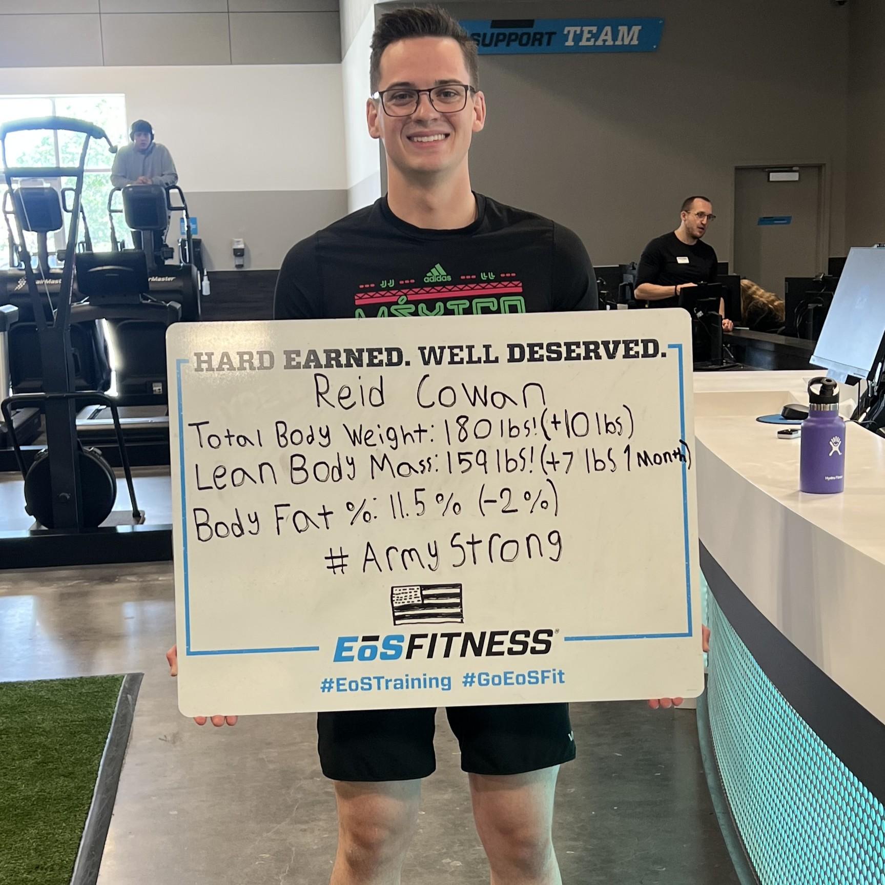 eos gym member standing side by side with personal trainer holding a white board listing reid lost weight from personal training