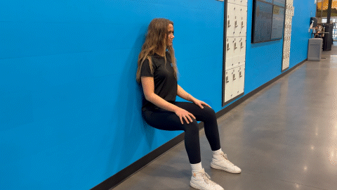 eos fitness member performing a wall sit