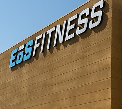 outside shot of a modern eos gym with brick walls and bright blue branding