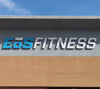 outside shot of a modern eos gym with brick walls and bright blue branding