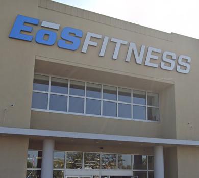 outside shot of a modern eos gym with brick walls and bright blue branding