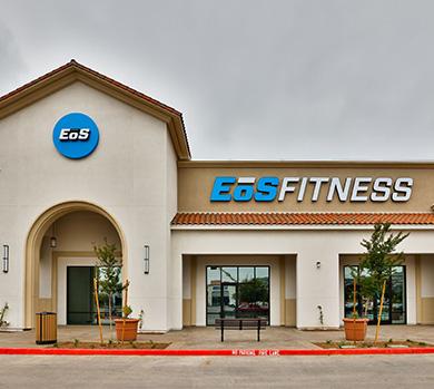 outside shot of a modern eos gym with brick walls and bright blue branding