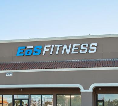 outside shot of a modern eos gym with brick walls and bright blue branding