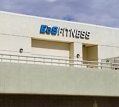 outside shot of a modern eos gym with brick walls and bright blue branding