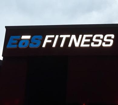 outside shot of a modern eos gym with brick walls and bright blue branding
