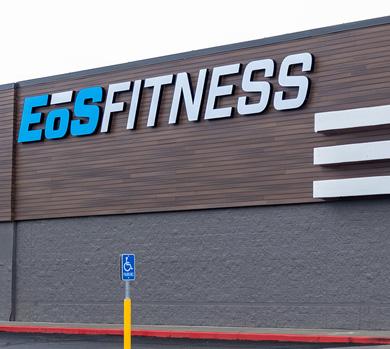 outside shot of a modern eos gym with brick walls and bright blue branding