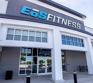 outside shot of a modern eos gym with brick walls and bright blue branding