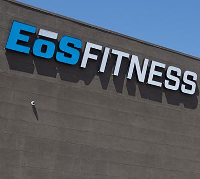 outside shot of a modern eos gym with brick walls and bright blue branding