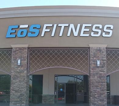 outside shot of a modern eos gym with brick walls and bright blue branding