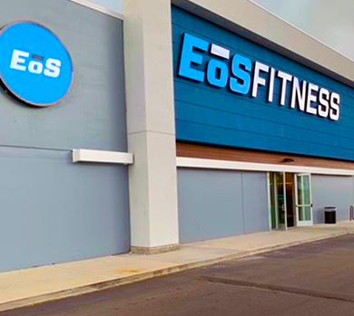 outside shot of a modern eos gym with brick walls and bright blue branding