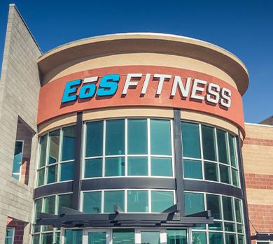 outside shot of a modern eos gym with brick walls and bright blue branding