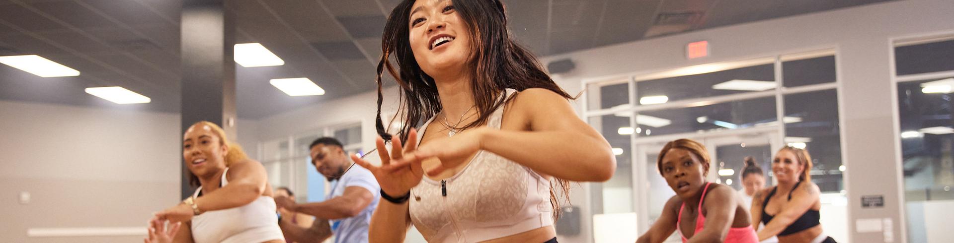 dance instructor leading a group of eos gym members in a dance class