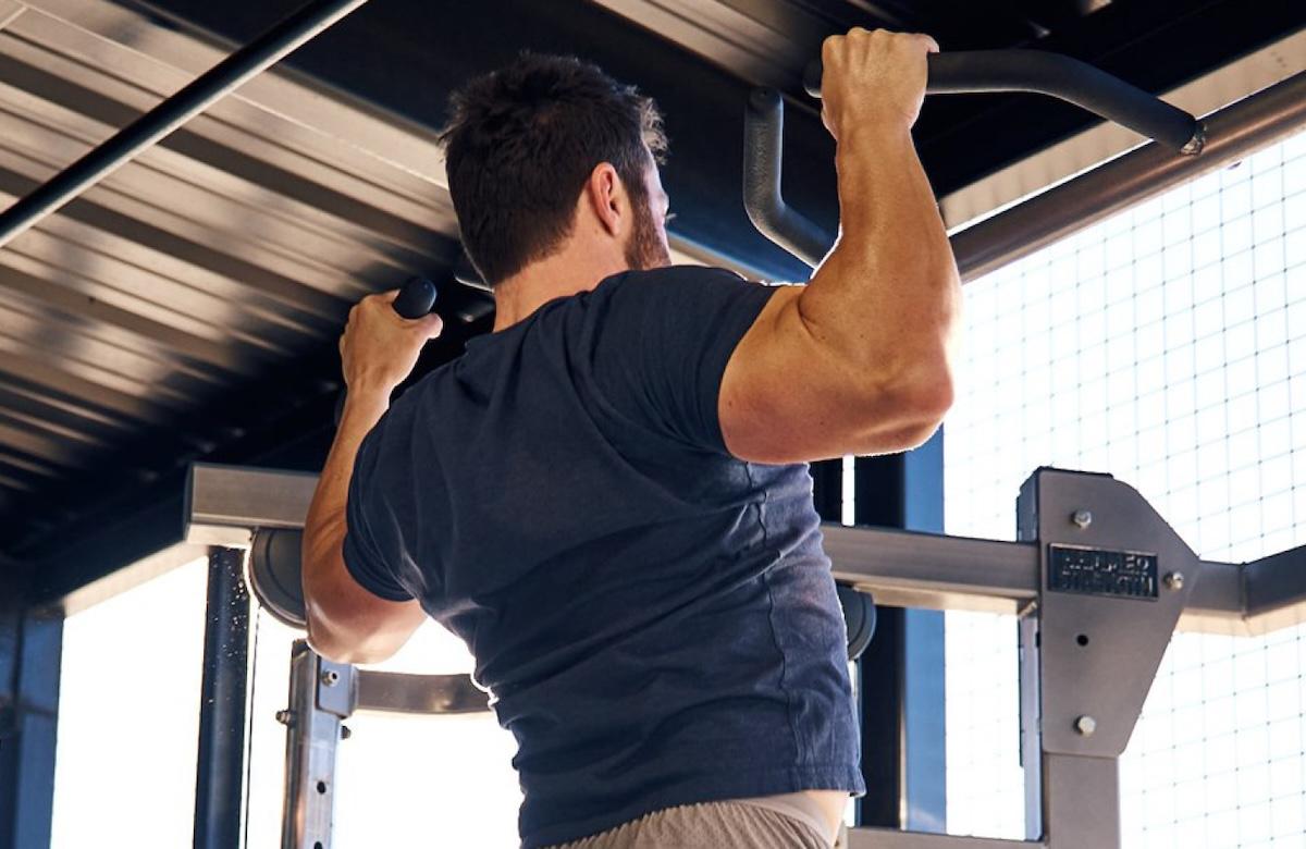 eos gym member doing pull ups in the backyard