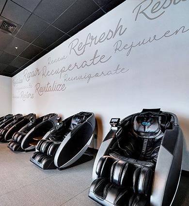 several high tech massage chairs in a well lit and clean eos branded room