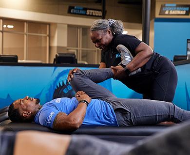 eos member laying on a table getting their leg stretched out by eos staff