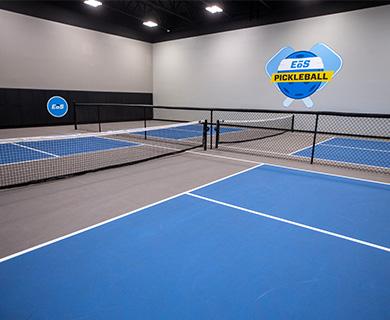 two empty indoor pickleball courts with eos branding