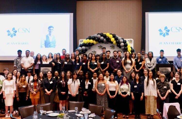 students stand on stage at the Project 150 luncheon