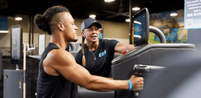 personal trainer hyping of eos gym member on smart equipment about to perform a row