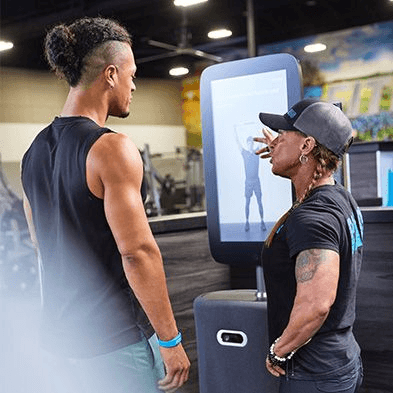 personal trainer explaining to excited eos gym member how the smart hub works