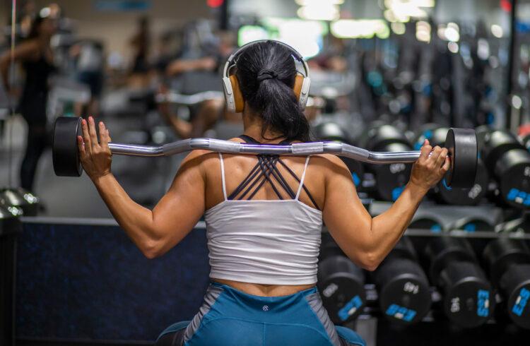 eos gym member squatting in the middle of a well lit and clean eos branded box gym