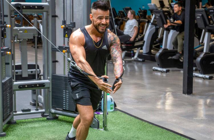 athletic eos gym member working on a cable fly machine