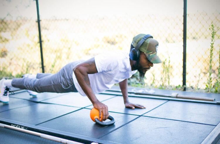 man in a gym doing a plank in an outdoor gym