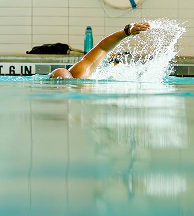 eos gym member freestyle swimming in a clean indoor pool