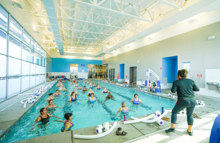 full indoor pool with instructor leading them on