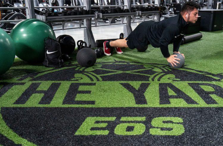 eos gym member doing pushup variations in eos branded turf