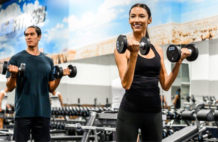 two eos gym members during curls in an eos branded box gym