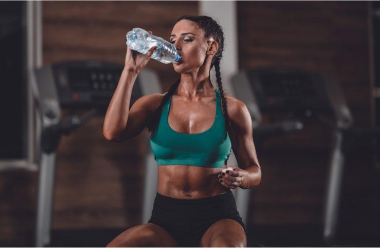 an athletic woman drinking water