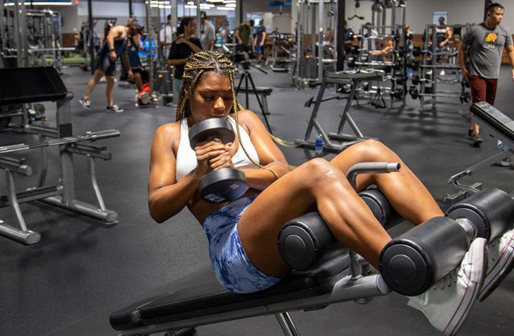 athletic eos gym member doing dumbbell crunches