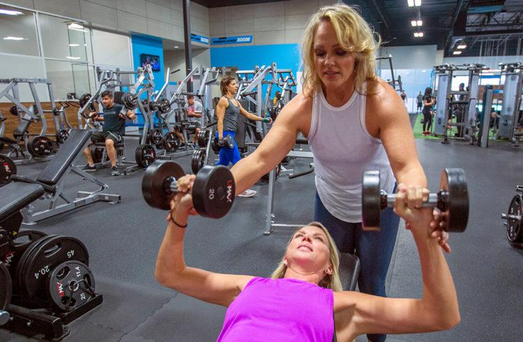 Two women working out at an EōS fitness gym