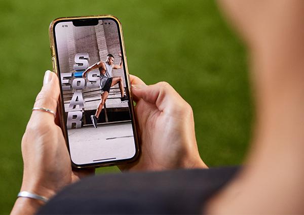 eos gym member looking down on their phone