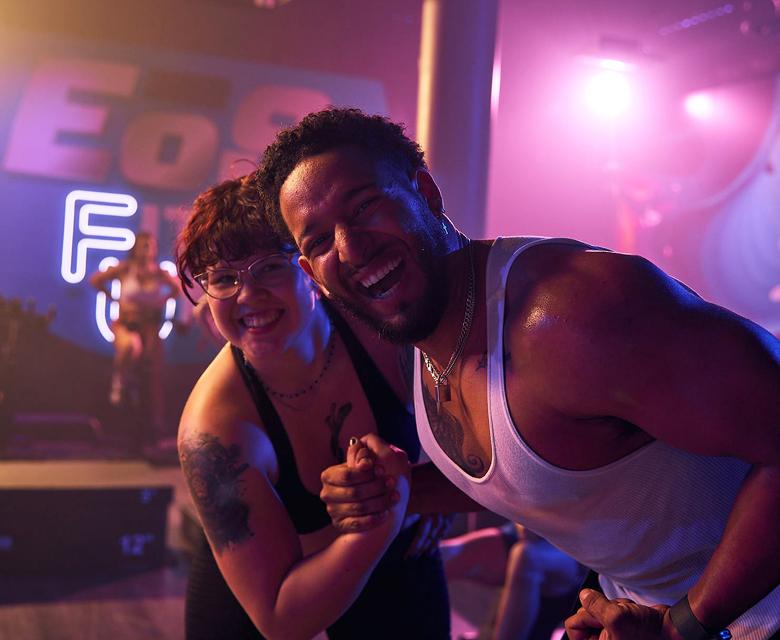 two eos gym members flexing and smiling at the camera