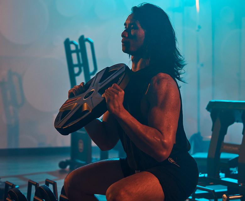 eos gym member doing goblet squat with plate