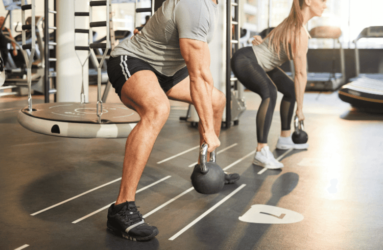two athletic gym members performing a lower body free weight workout