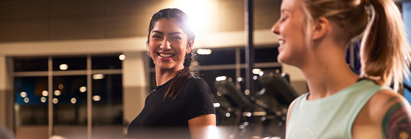 two eos gym members smiling at each other