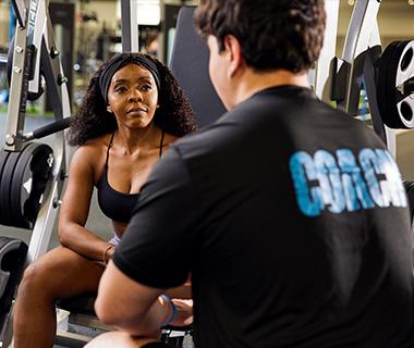 personal trainer helping eos gym member with exercise