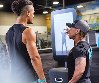 personal trainer helping eos gym member with exercise