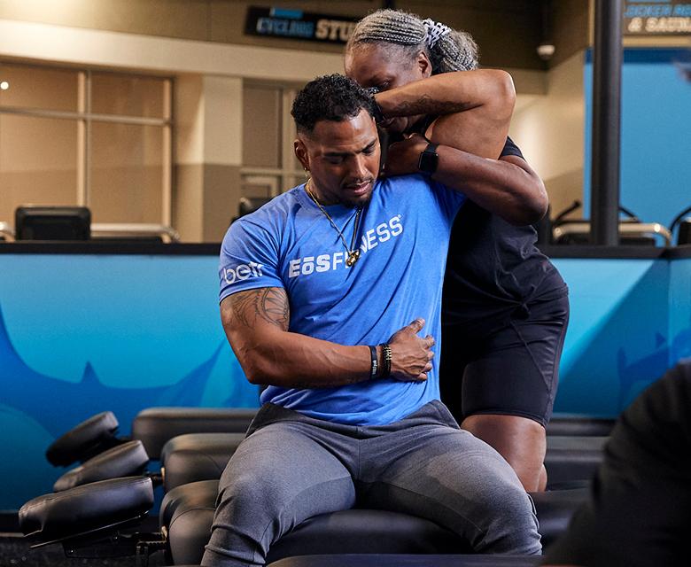 eos gym member getting their shoulder stretched out