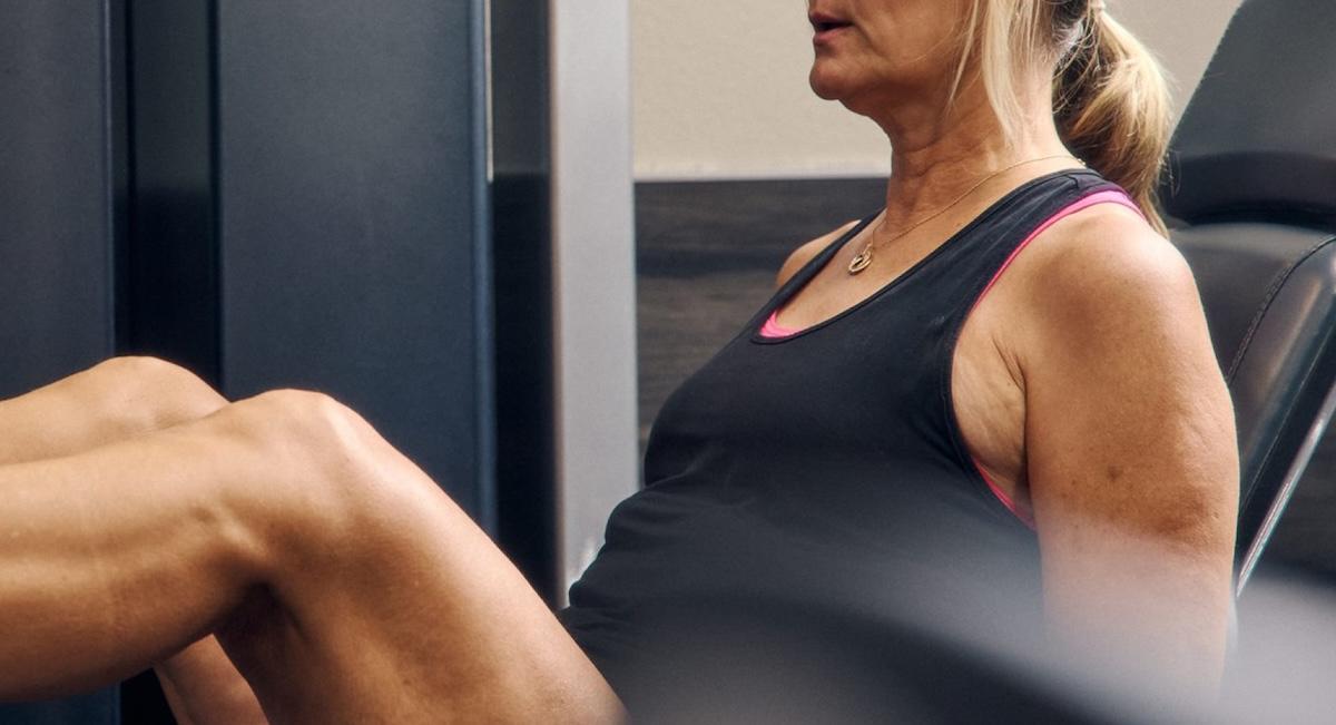A woman performing a squat with a resistance band at home