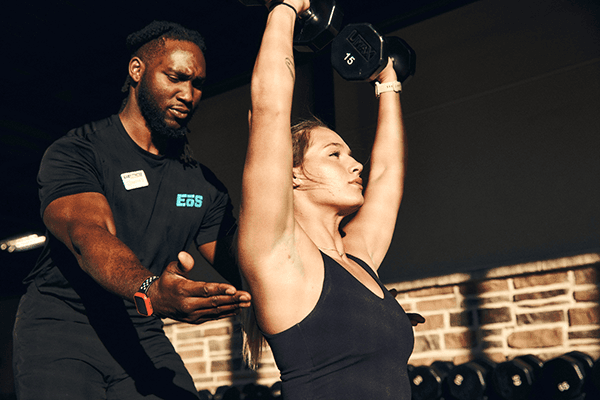 eos gym member doing dumbell workout with personal trainer