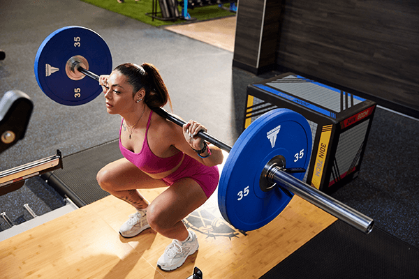 eos gym member doing a barbell squat