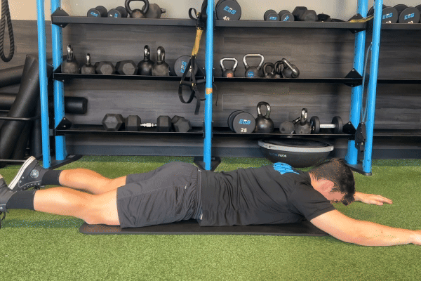 eos gym member doing supermans on yoga mat